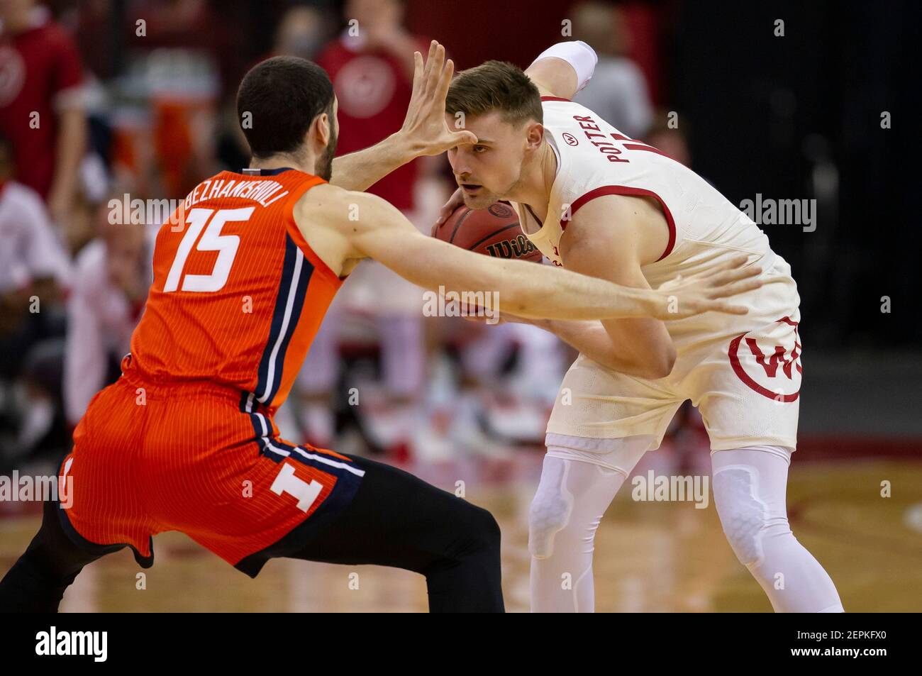 Madison, WISCONSIN, Stati Uniti. 27 Feb 2021. 11 Micah Potter guarda alla guida mentre viene difeso dall'Illinois Fighting Illinois Forward Giorgi Bezhanishvili 15 durante la partita di pallacanestro NCAA tra l'Illinois Fighting Illinois e i tassi del Wisconsin al Kohl Center di Madison, WISCONSIN. John Fisher/CSM/Alamy Live News Foto Stock