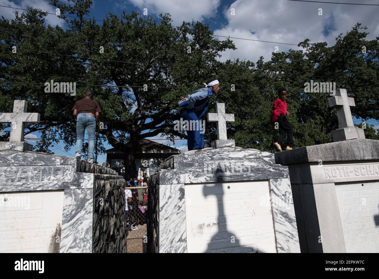 Giovani uomini che ballano su tombe e tombe nel cimitero durante Prince of Wales, New Orleans Social Aid e Pleasure Club Second Line (seconda linea). Foto Stock