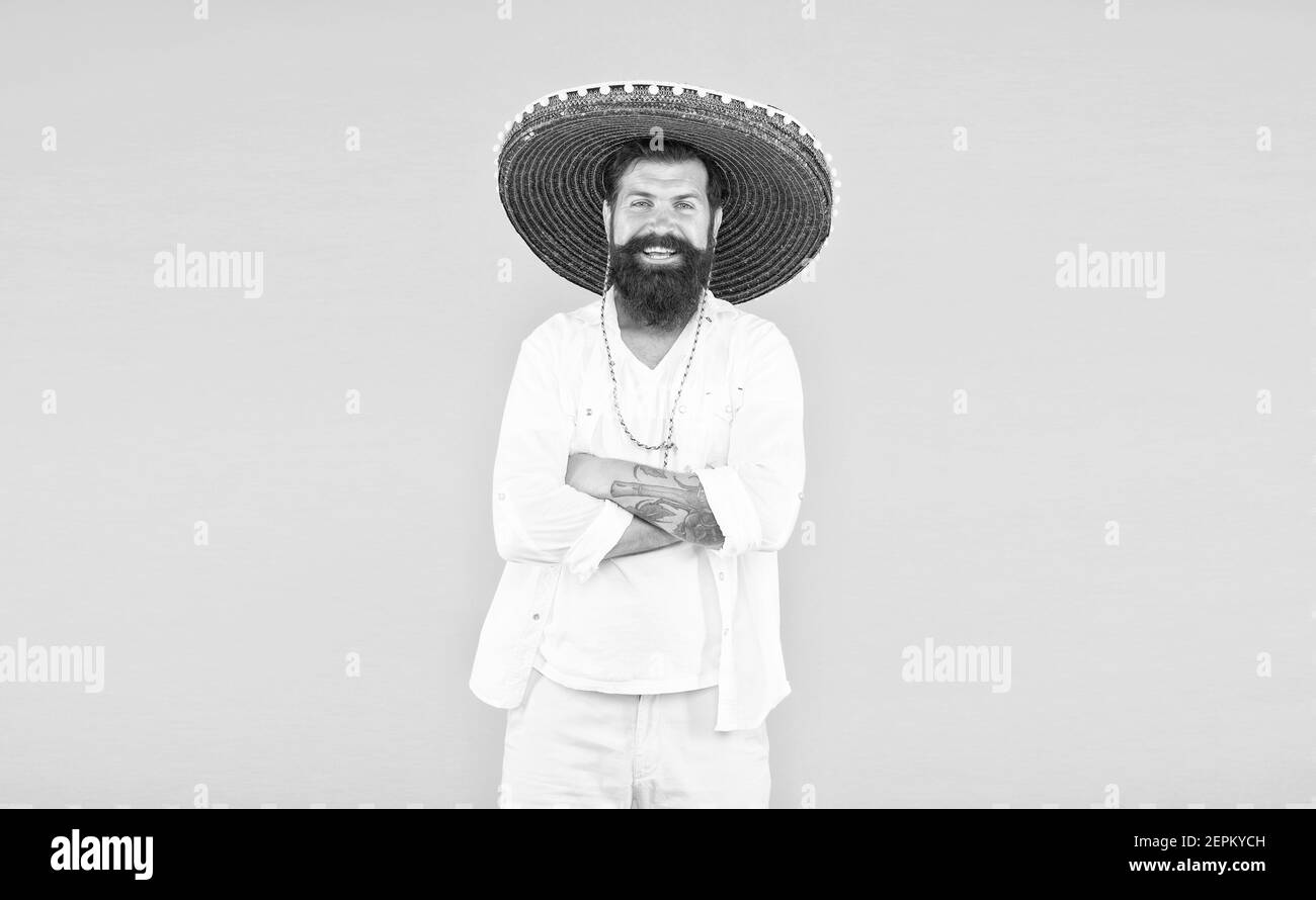 uomo in cappello sombrero messicano. concetto di vacanza al resort in messico. hipster con barba appare festoso in sombrero. felice maschio brutale festeggiando fiesta. ragazzo indossa poncho. sombrero party man. Foto Stock