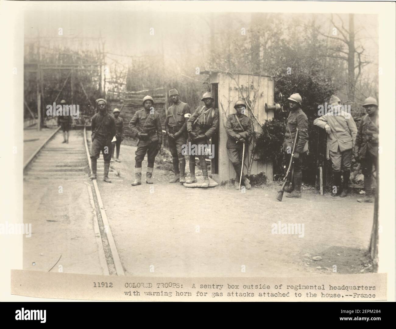 WW1 WWI ufficiale fotografia militare degli Stati Uniti di soldati di combattimento neri che servono in Francia. Didascalia "una cassetta di sicurezza al di fuori del quartier generale del reggimento con corno di avvertimento per gli attacchi di gas attaccati alla casa Francia" Foto Stock