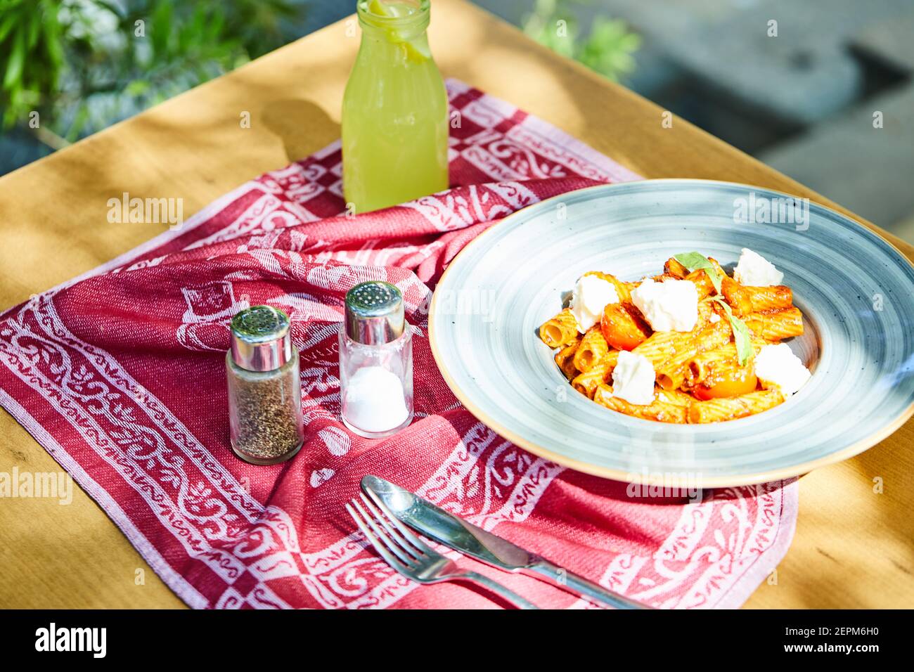 Pasta fritta con formaggio e pomodori con limonata, sale Foto Stock