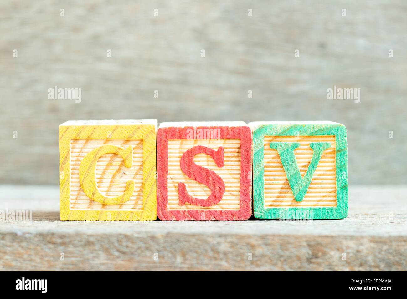 Blocco di lettere alfabetiche a colori in CSV di parole (Abbreviazioni della convalida del sistema informatico o valori separati da virgole) su sfondo di legno Foto Stock