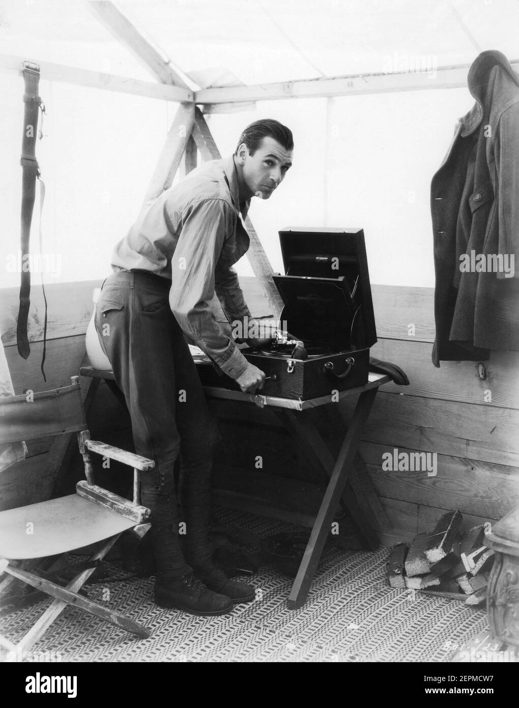 GARY COOPER nel suo costume uniforme della prima guerra mondiale fa salire il suo fonografo portatile Columbia nella sua tenda dopo una dura giornata di lavoro sul posto a 35 miglia da Los Angeles filmando UN UOMO DAL regista DEL WYOMING 1930 ROWLAND V. LEE Paramount Pictures Foto Stock