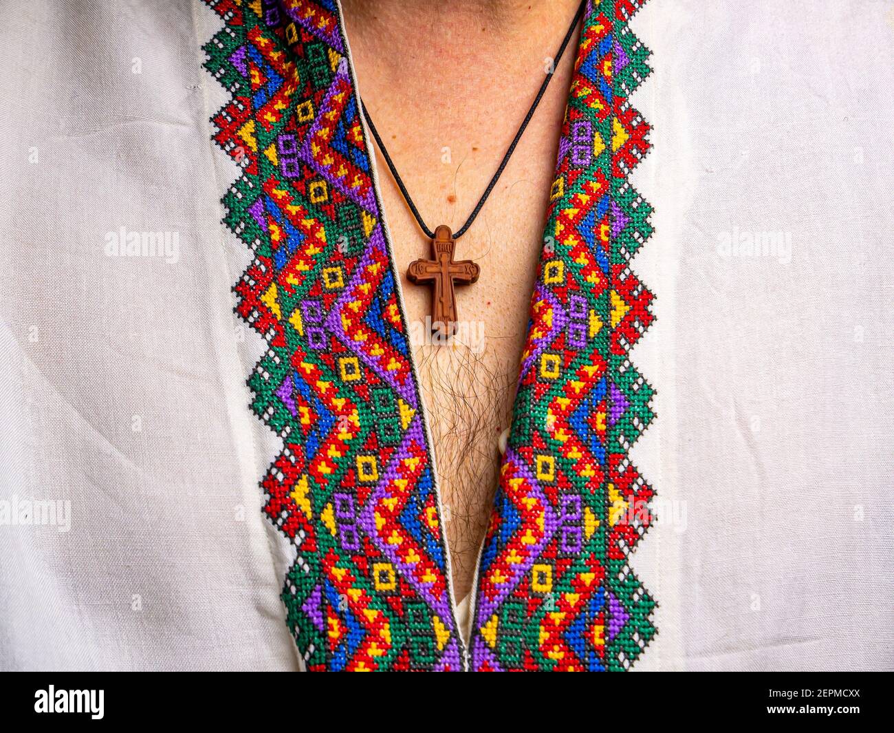 Croce pettorale cristiana sul petto maschile. Cresta pettorale ortodossa. Abiti tradizionali nazionali. Cultura e tradizioni ucraine. Pattern su un Whi Foto Stock