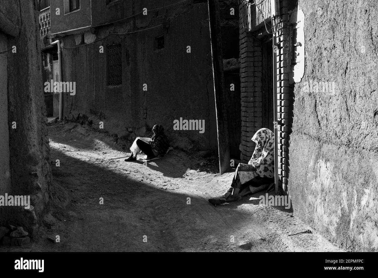 Donne che godono gli ultimi minuti di sole nell'antica città di Abyaneh nella rurale Iran. La gente ad Abyaneh parla un'antica versione del persiano. Foto Stock