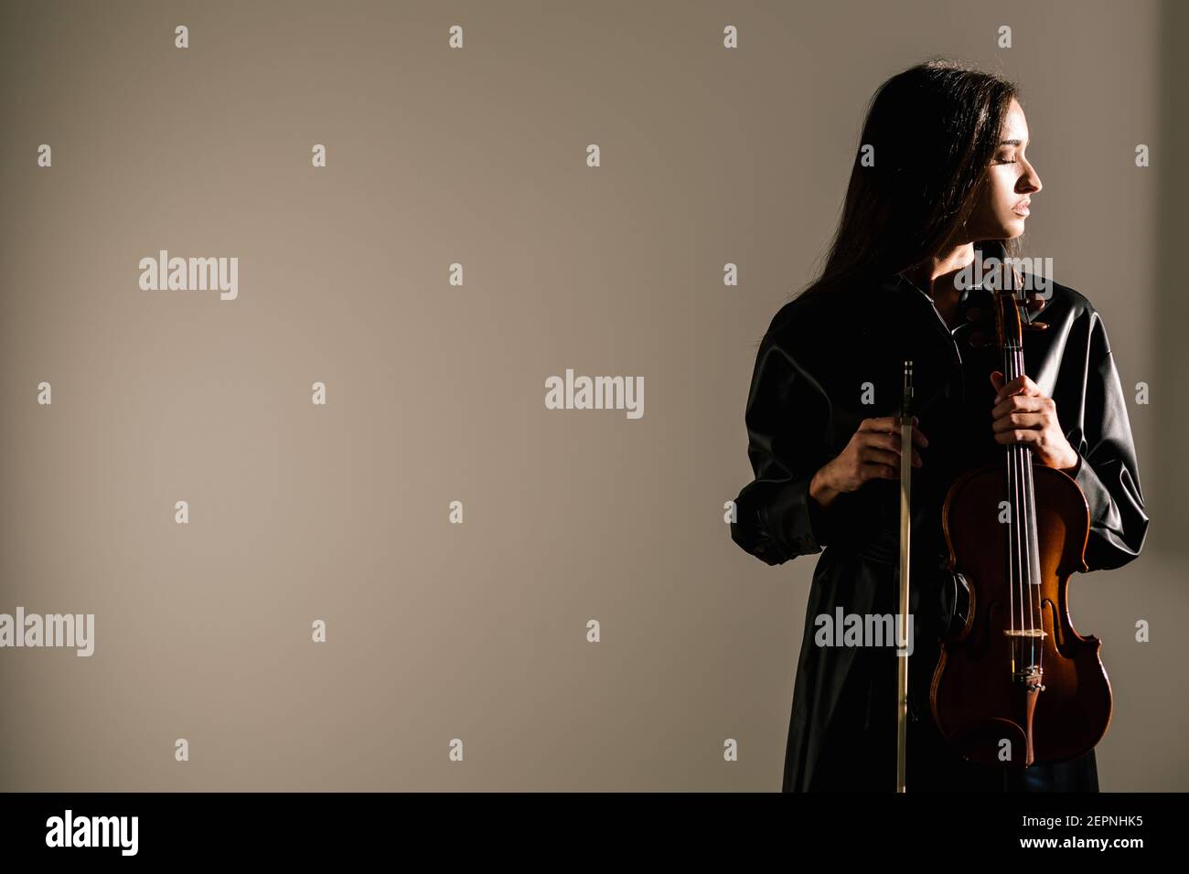 Violinista femminile in piedi con strumento musicale e occhi chiusi con cura  Foto stock - Alamy