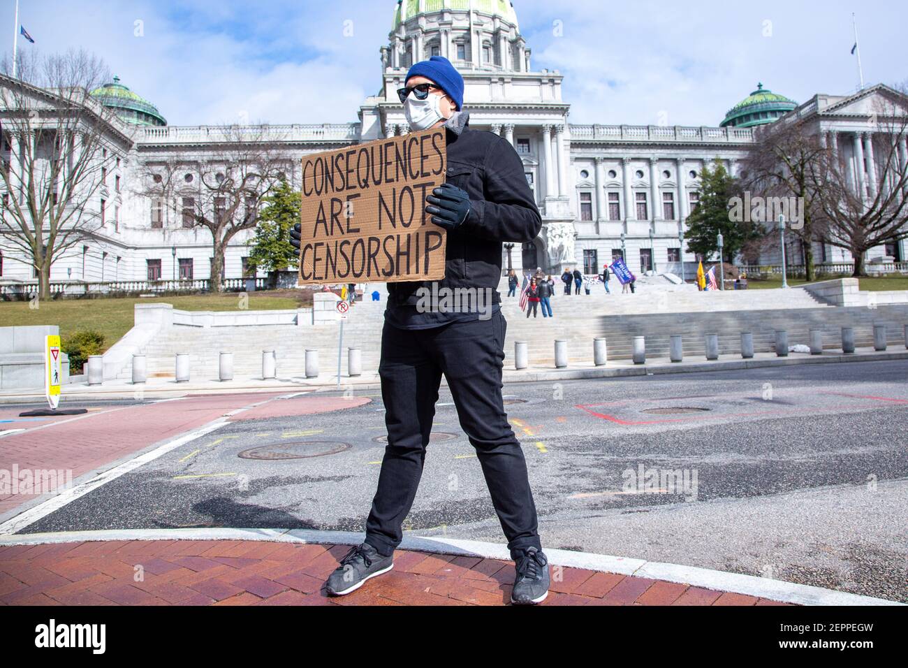 Harrisburg, Stati Uniti. 27 Feb 2021. Un contro-protetore tiene un cartello che esprime la sua opinione dall'altra parte della strada dal Campidoglio di Stato della Pennsylvania.circa 40 persone si sono riunite sui gradini del Campidoglio di Stato della Pennsylvania per il '1° emendamento--conservatori che sono censurati' rally. Credit: SOPA Images Limited/Alamy Live News Foto Stock