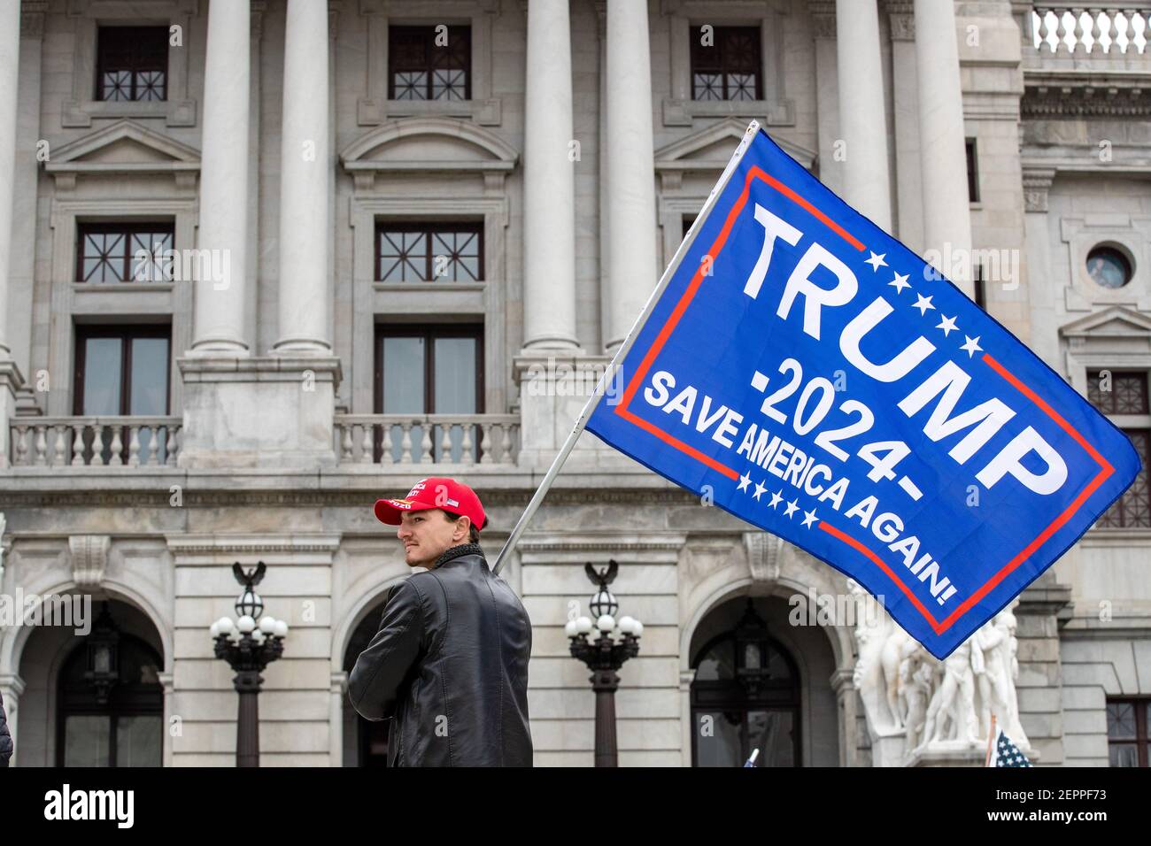 Harrisburg, Stati Uniti. 27 Feb 2021. Un manifestante detiene una bandiera di Trump 2024 davanti al Campidoglio dello Stato della Pennsylvania.circa 40 persone si sono riunite sui gradini del Campidoglio dello Stato della Pennsylvania per il '1° emendamento--i conservatori sono censurati' rally. Credit: SOPA Images Limited/Alamy Live News Foto Stock