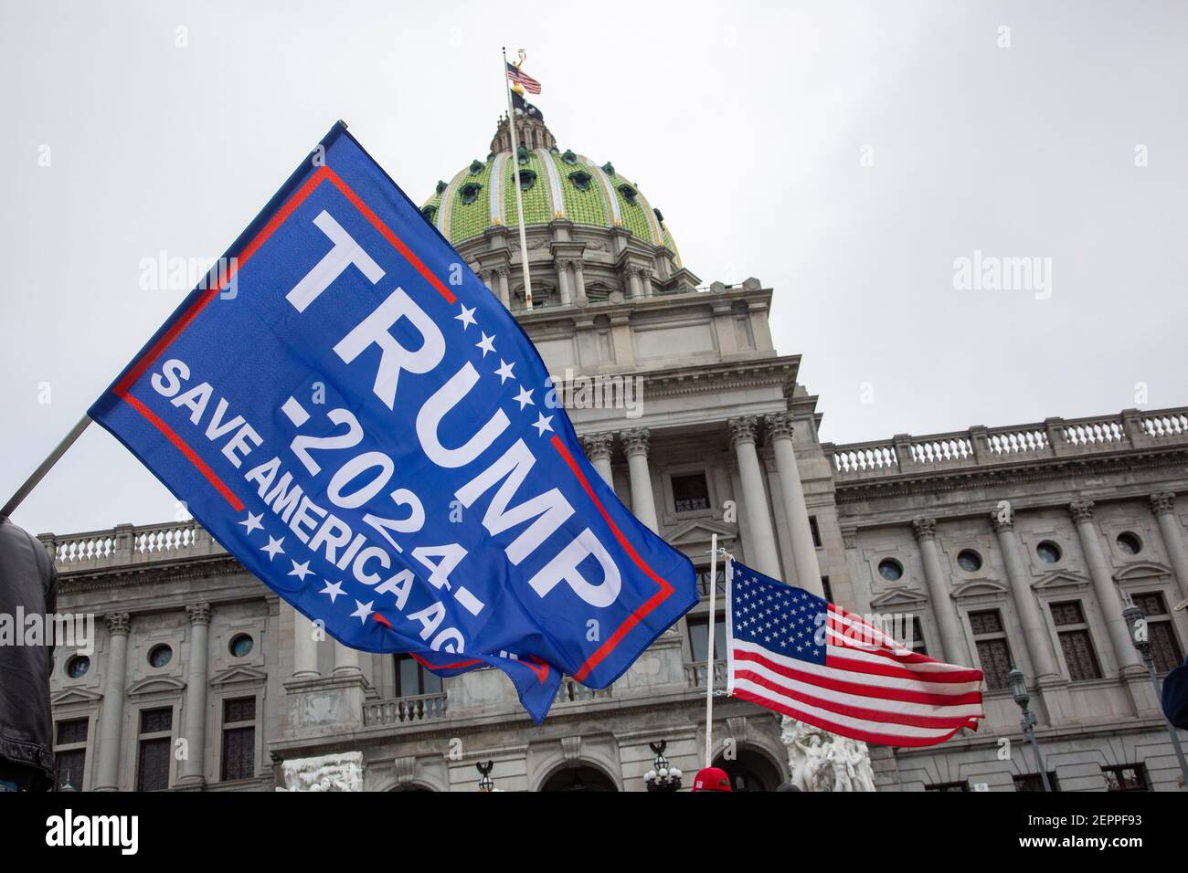 Harrisburg, Stati Uniti. 27 Feb 2021. Un manifestante detiene una bandiera di Trump 2024 davanti al Campidoglio dello Stato della Pennsylvania.circa 40 persone si sono riunite sui gradini del Campidoglio dello Stato della Pennsylvania per il '1° emendamento--i conservatori sono censurati' rally. Credit: SOPA Images Limited/Alamy Live News Foto Stock