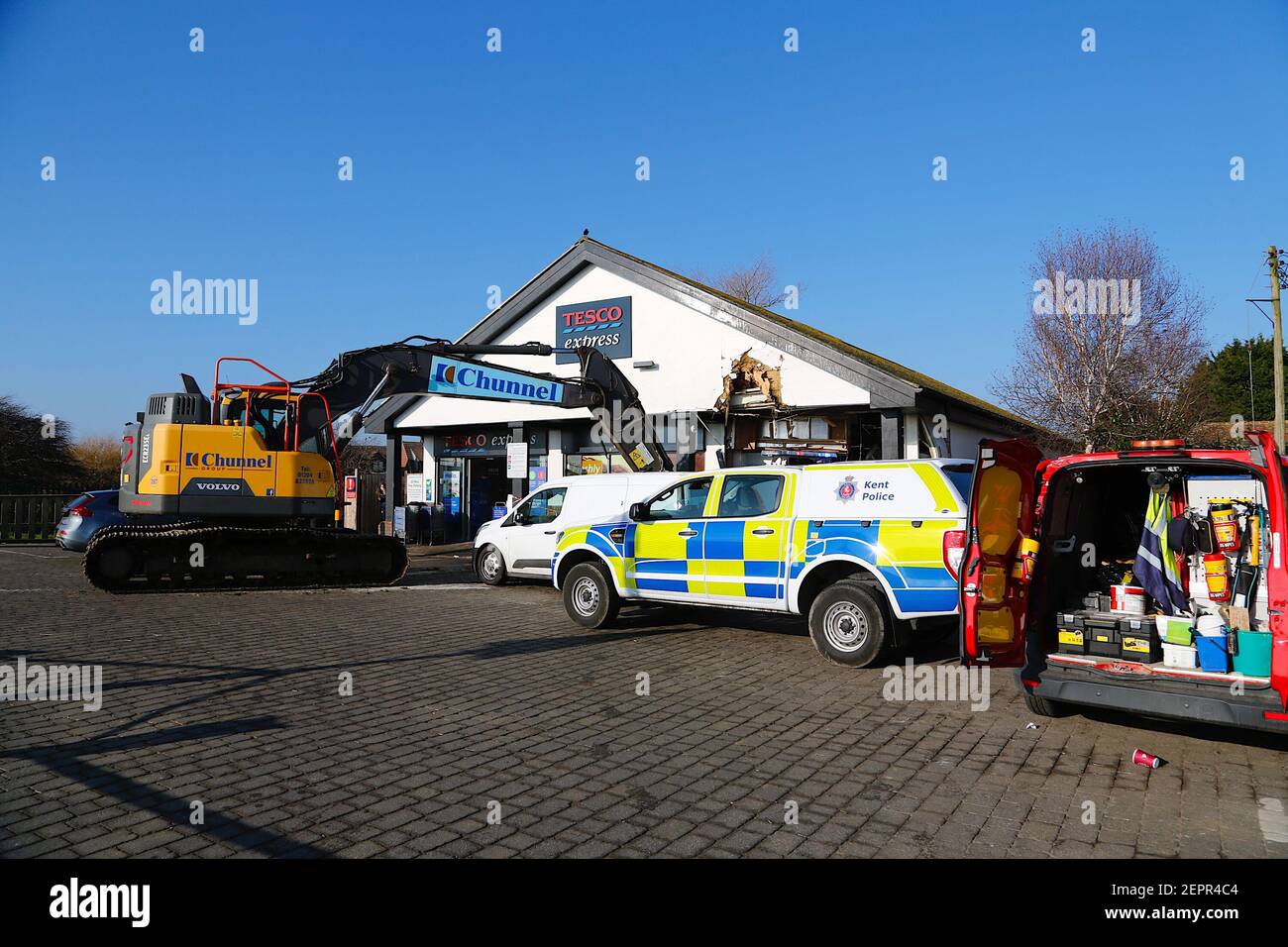 Dymchurch, Kent, Regno Unito. 28 febbraio 2021. I ladri immolati hanno tentato un’audace incursione su questo Tesco express in via Dymchurch Hugh avendo guidato un escavatore cingolato Volvo ECR235E nelle prime ore del mattino in una tentata rapina da cashpoint. Un negozio di fronte è stato lasciato con 'danno significativo' in un tentativo fallito di strappare una macchina di cassa con un digger, la polizia dice. Un angolo dell'edificio si trova in tatters. Si credeva che il digger fosse stato rubato da Dymchurch Beach. Photo Credit: Paul Lawrenson/Alamy Live News Foto Stock