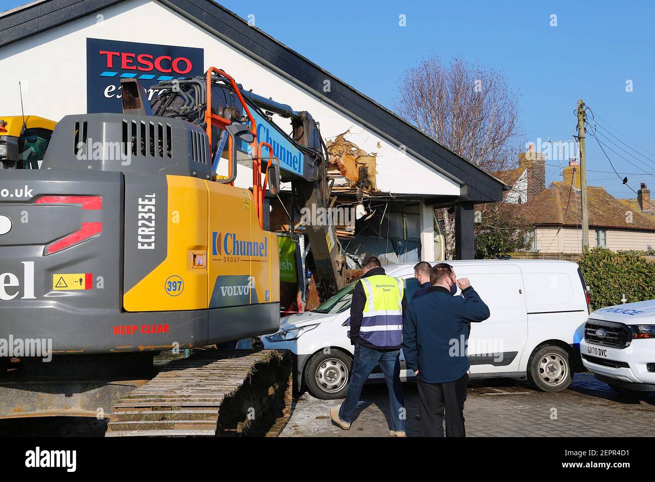 Dymchurch, Kent, Regno Unito. 28 febbraio 2021. I ladri immolati hanno tentato un’audace incursione su questo Tesco express in via Dymchurch Hugh avendo guidato un escavatore cingolato Volvo ECR235E nelle prime ore del mattino in una tentata rapina da cashpoint. Un negozio di fronte è stato lasciato con 'danno significativo' in un tentativo fallito di strappare una macchina di cassa con un digger, la polizia dice. Un angolo dell'edificio si trova in tatters. Si credeva che il digger fosse stato rubato da Dymchurch Beach. Photo Credit: Paul Lawrenson/Alamy Live News Foto Stock