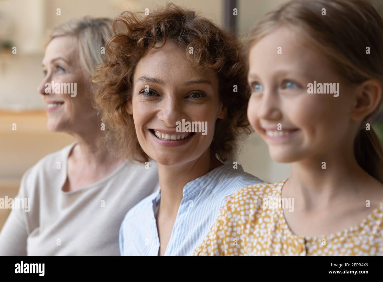 Le femmine della famiglia multigenerazionale di età diversa si siedono in fila insieme Foto Stock