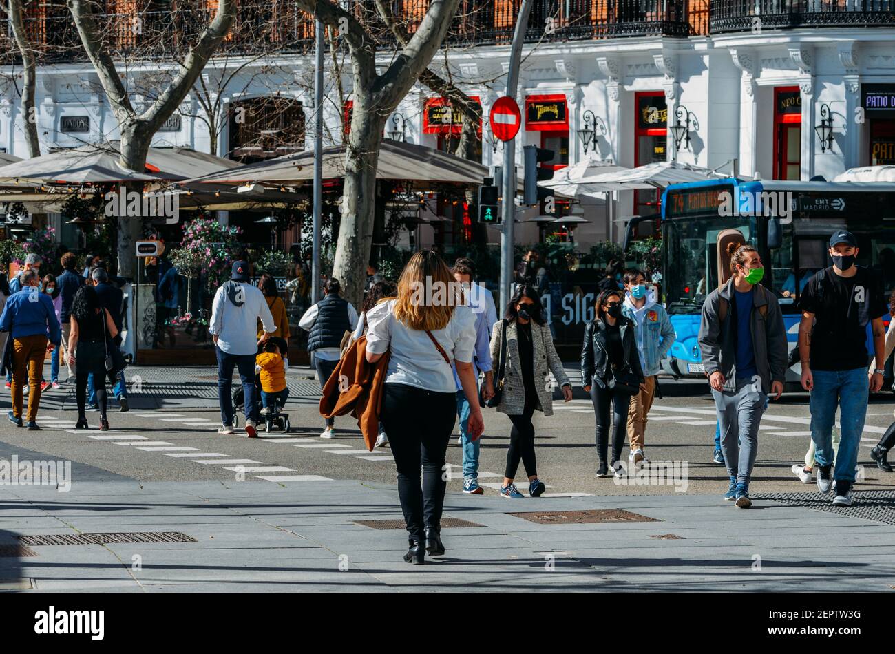 Madrid, Spagna - 28 febbraio 2021: Gruppo di persone in traversata pedonale. Nuova situazione in Spagna in merito alla pandemia di Covid-19. La gente usa mas Foto Stock