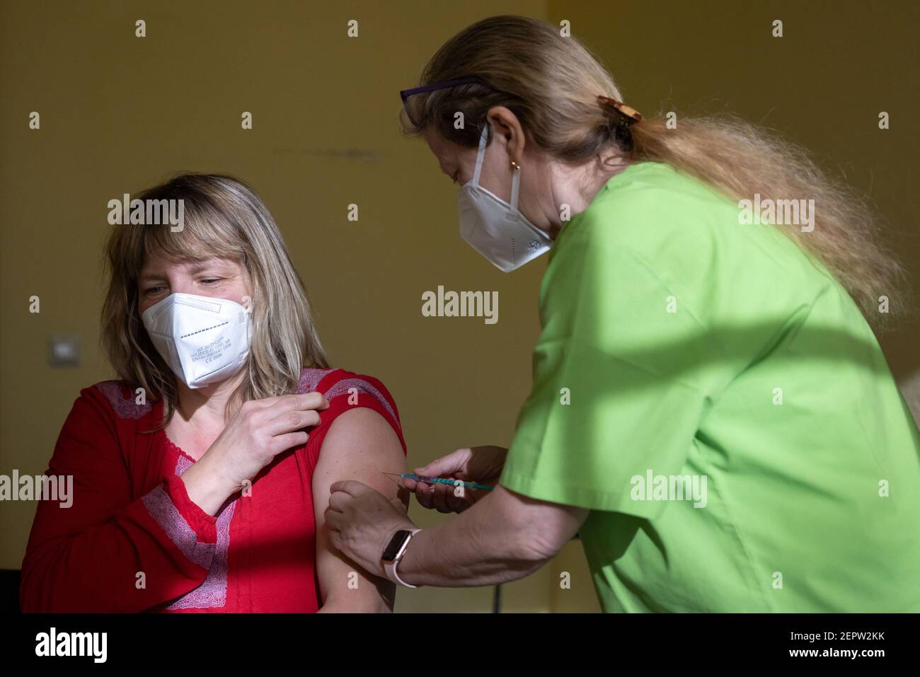 Apolda, Germania. 28 Feb 2021. Anke Mühlberg (l), dipendente di un asilo, riceve la vaccinazione Corona con il farmaco di AstraZeneca da Sylvia Baumbach presso il centro di vaccinazione di Apolda. Si prevede che oggi, presso i centri di vaccinazione, un totale di 5,350 dipendenti delle scuole elementari e speciali e degli asili della Turingia riceverà la prima vaccinazione a Corona. Credit: Michael Reichel/dpa-Zentralbild/dpa/Alamy Live News Foto Stock