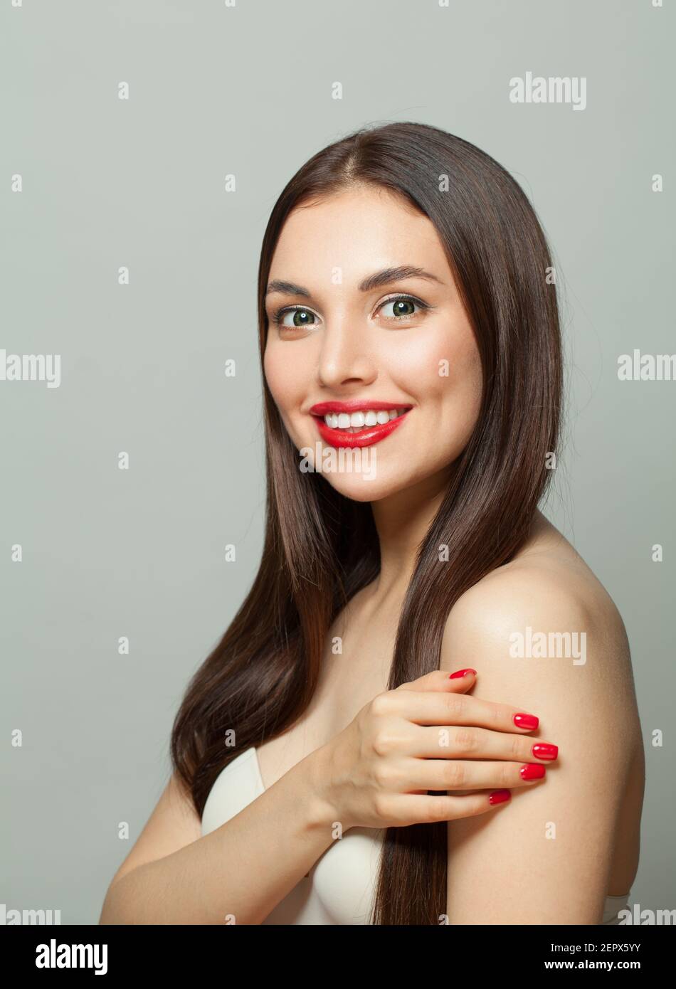 Donna giovane felice con pelle chiara e lungo sano diritto capelli su sfondo bianco Foto Stock