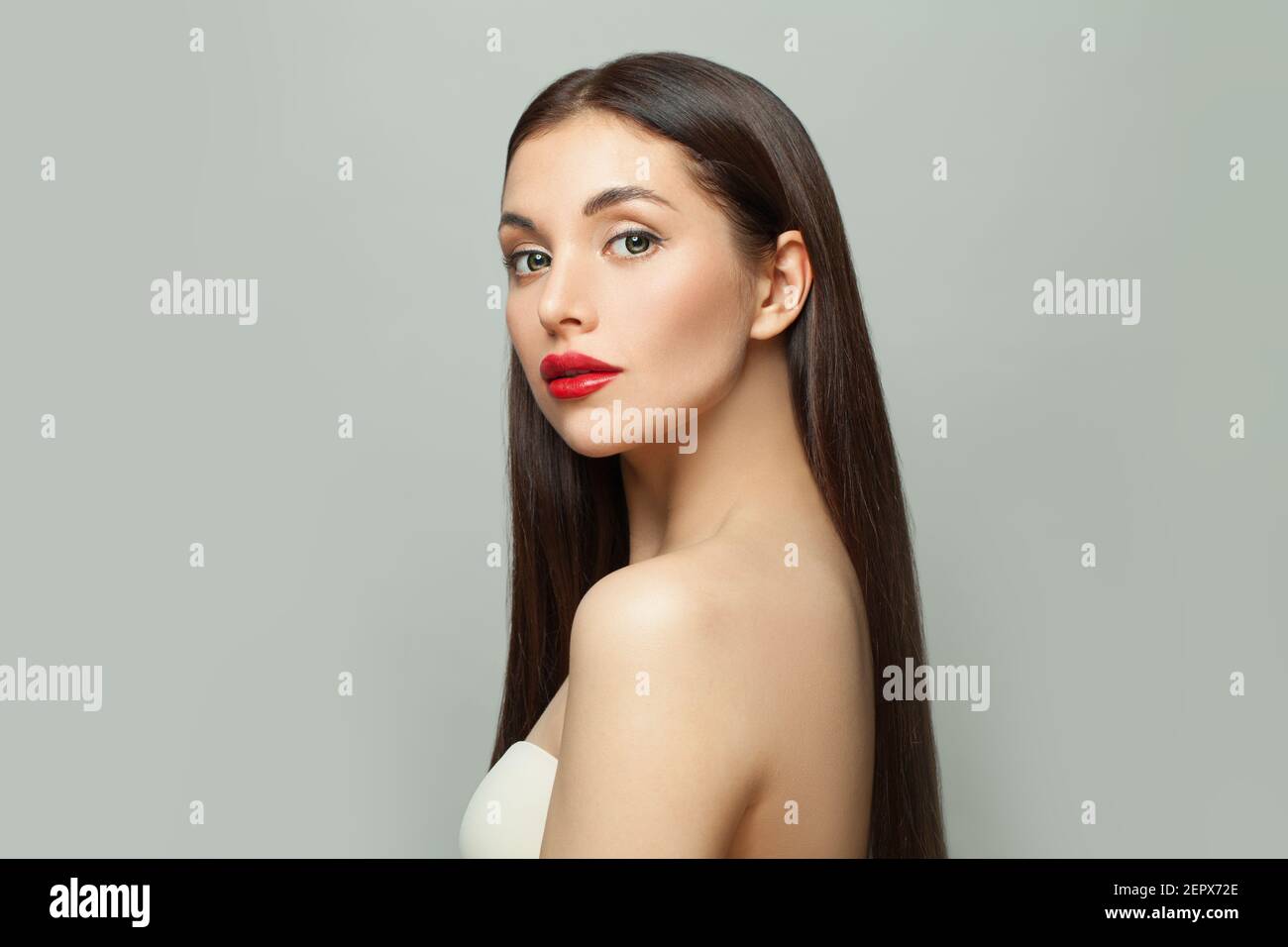 Bella moda modello donna brunette con pelle chiara e lunga capelli lisci sani su sfondo bianco Foto Stock