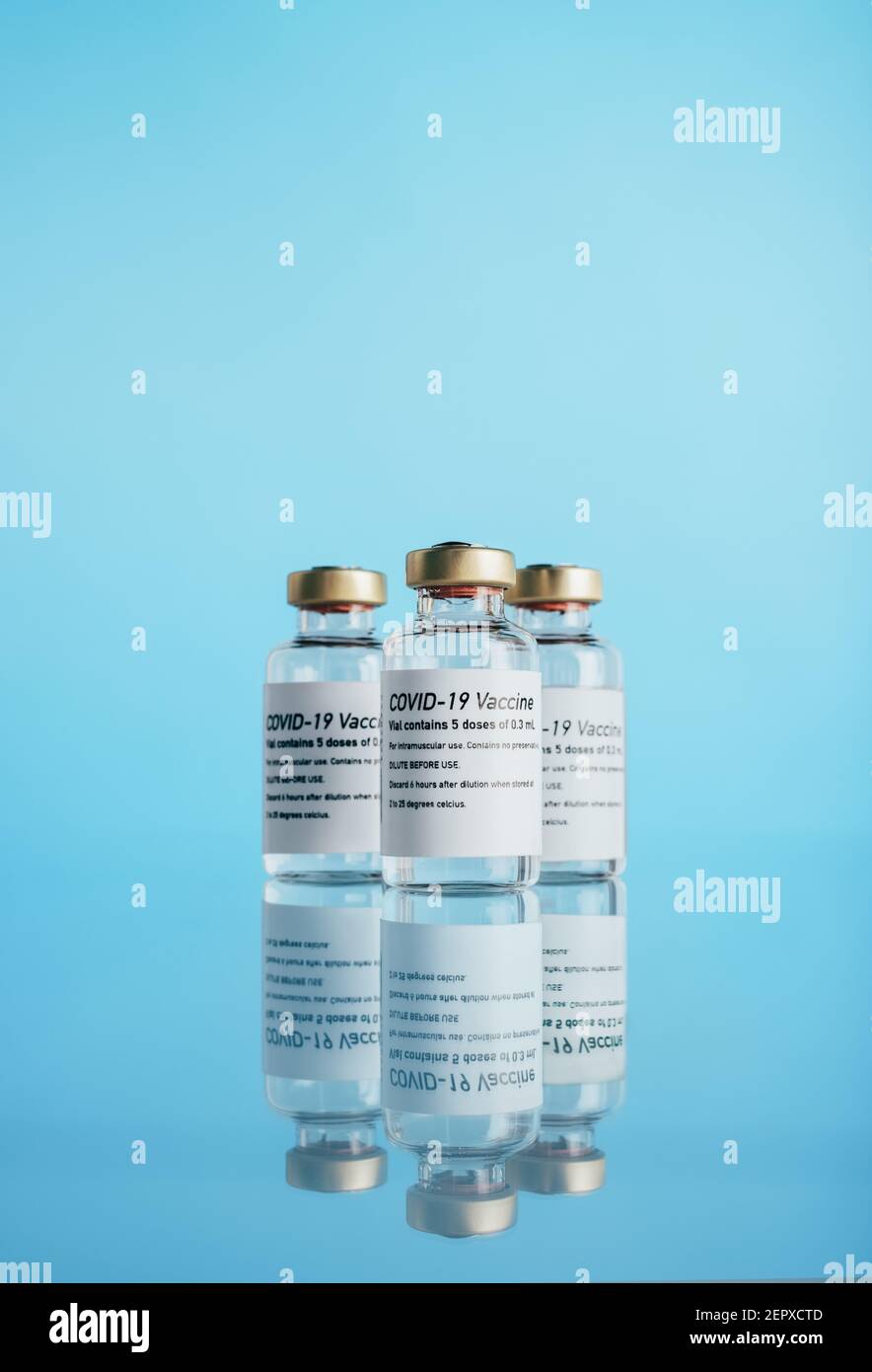 Tre flaconcini di vaccino covid-19. Flaconi di vaccinazione del virus Corona su sfondo blu. Foto Stock