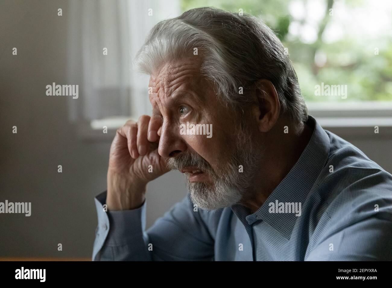 Confuso sconvolto vecchio anni 70 uomo invecchiato sfregando viso e occhio Foto Stock