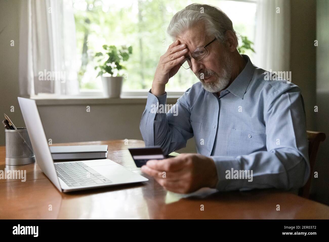 Uomo anziano sconvolto preoccupato per la sicurezza finanziaria Foto Stock