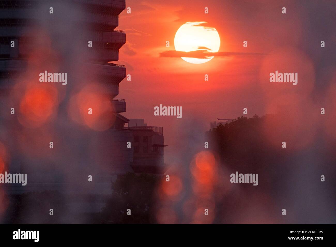 Singapore. 28 Feb 2021. La luce di un sole tramonta passa attraverso una fontana d'acqua nel Singapore Sports Hub il 28 febbraio 2021. Credit: Allora Chih Wey/Xinhua/Alamy Live News Foto Stock