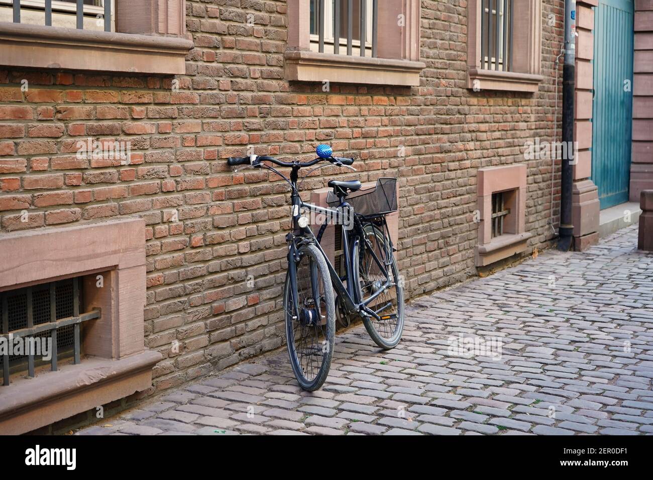 Tipica vecchia strada nella storica Düsseldorf vecchia con un edificio in pietra di mattoni, una vecchia bicicletta e un pavimento in ciottoli. Foto Stock