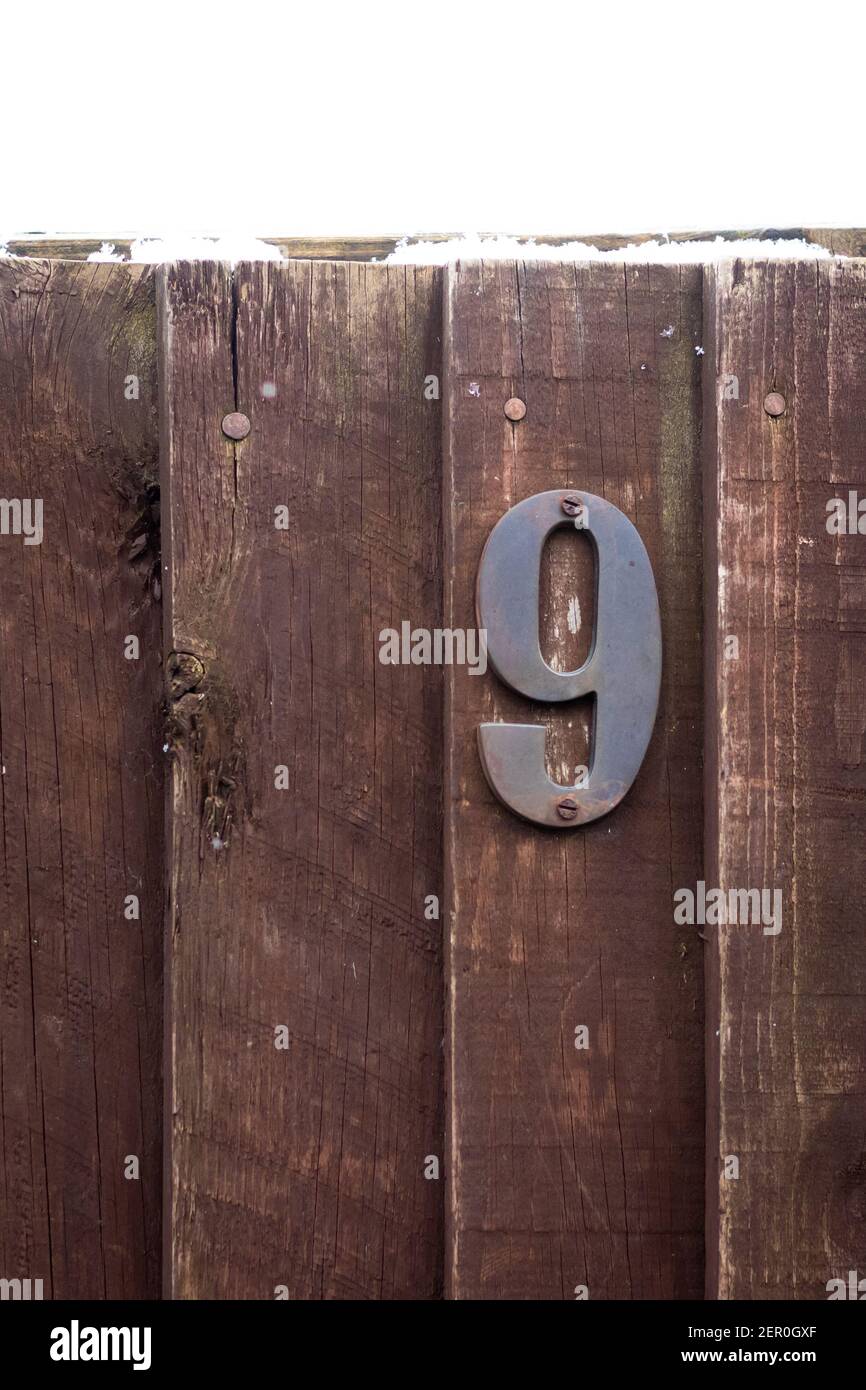 Casa numero 9 su una recinzione di legno ruvida Foto Stock