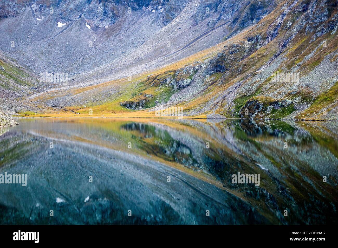 Lago alpino Kratzenbergsee. Riflessioni sull'acqua del lago, simmetrie. Hollersbachtal. Gruppo di montagna Venediger. Alpi austriache. Europa. Foto Stock