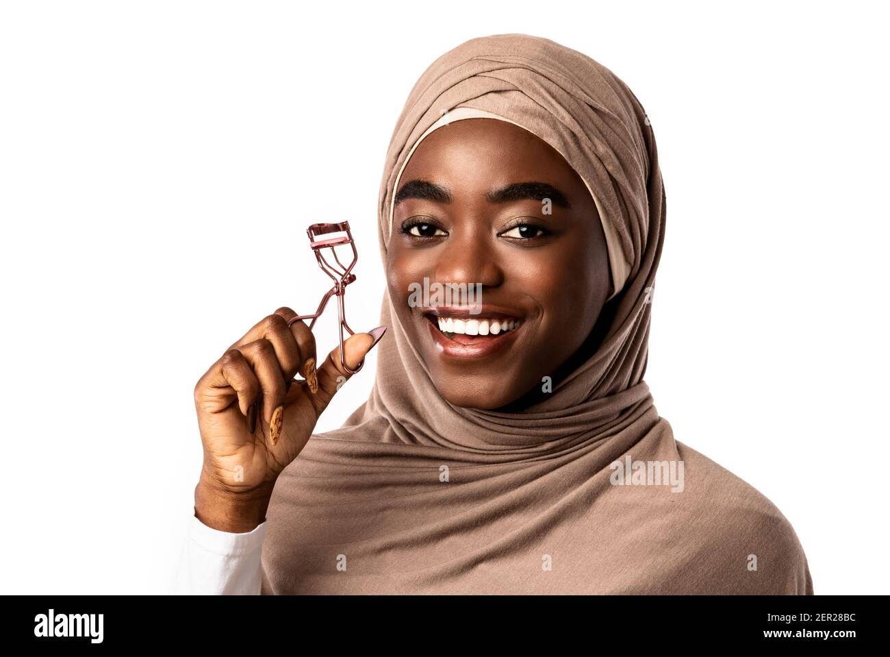 Ritratto di musulmana African American modello femminile utilizzando Eyelash Curler Foto Stock