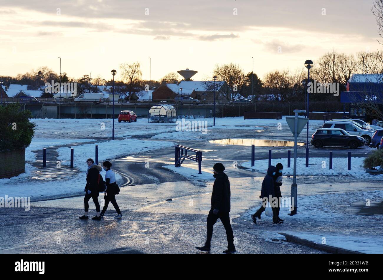 Persone che camminano nella neve con il parcheggio Range sullo sfondo. Foto Stock