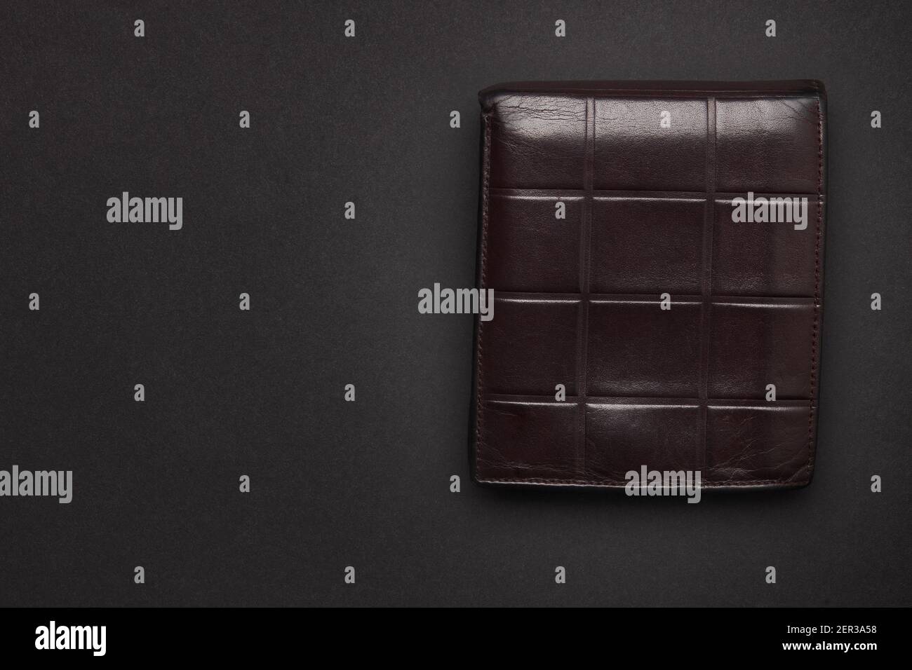 portafoglio in pelle marrone su sfondo nero. vista dall'alto. studio shot. copia spazio per il design. concetto di investimento e risparmio Foto Stock