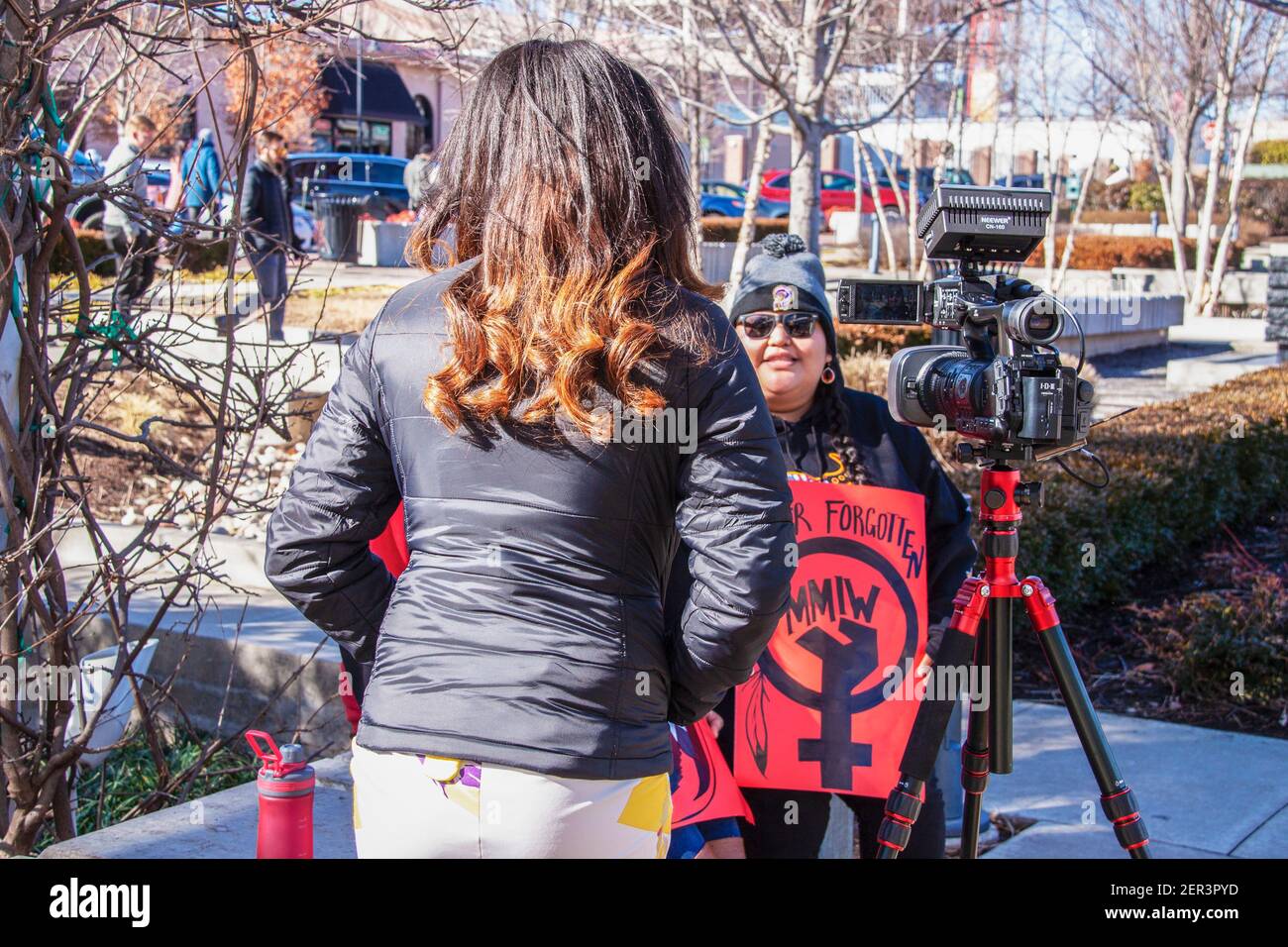 1-18-2018 Tulsa USA retro di una reporter donna videotaping intervista con Protestore nativo americano con MMIW - ASSASSINATO e INDIGENO MANCANTE DONNE- segno Foto Stock