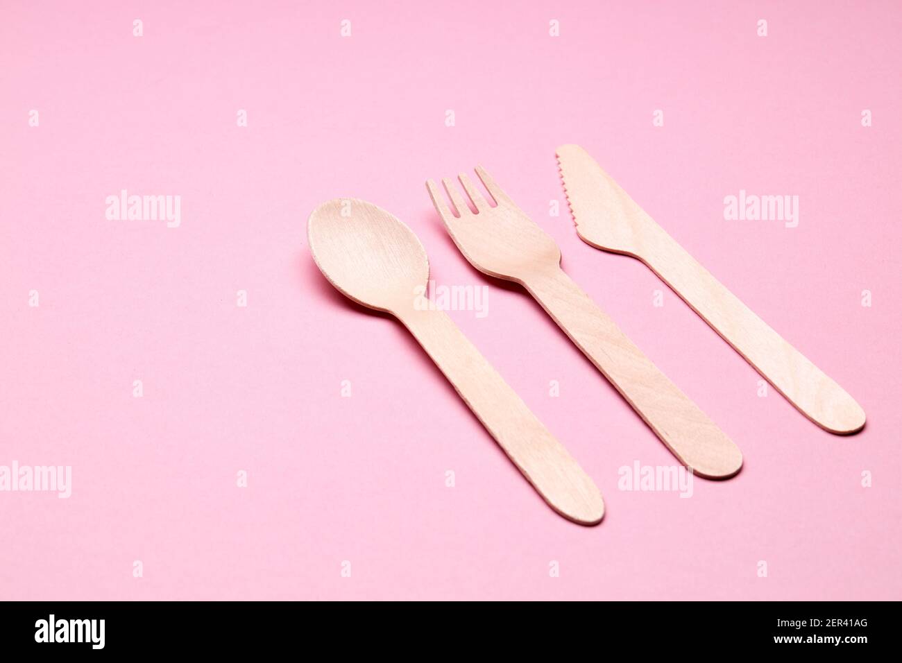 concetto di utensili monouso eco-friendly. posate di bambù o legno su sfondo di colore rosa Foto Stock