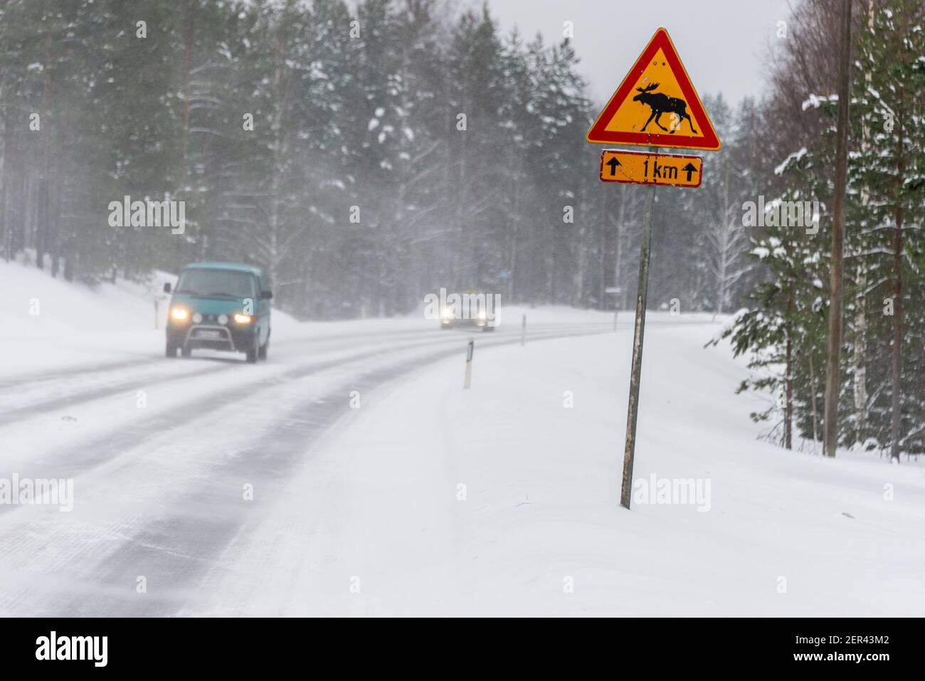 Guida sulla neve su una strada principale attraverso il paese di Moose in Finlandia. Foto Stock