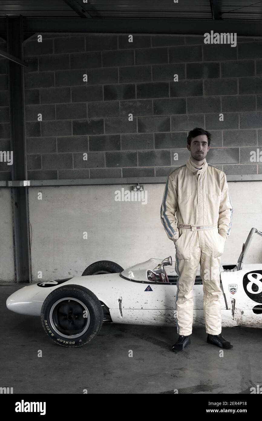 Ritratto del giovane pilota di auto da corsa con la sua Lotus 1962 auto da corsa vintage 22 Foto Stock