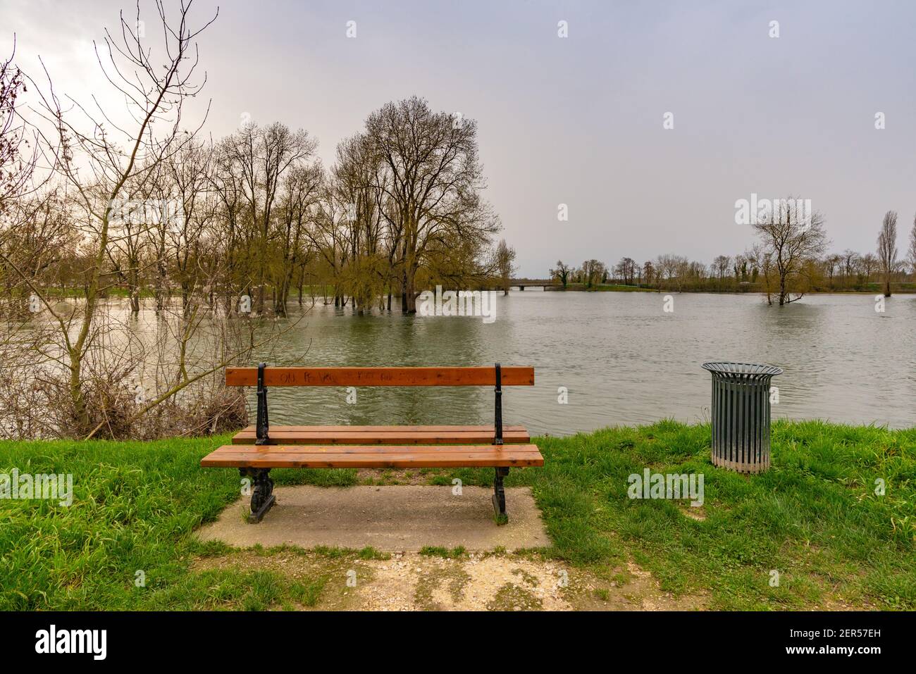 Una panchina che si affaccia su una campagna allagata a Saintes, in Francia Foto Stock