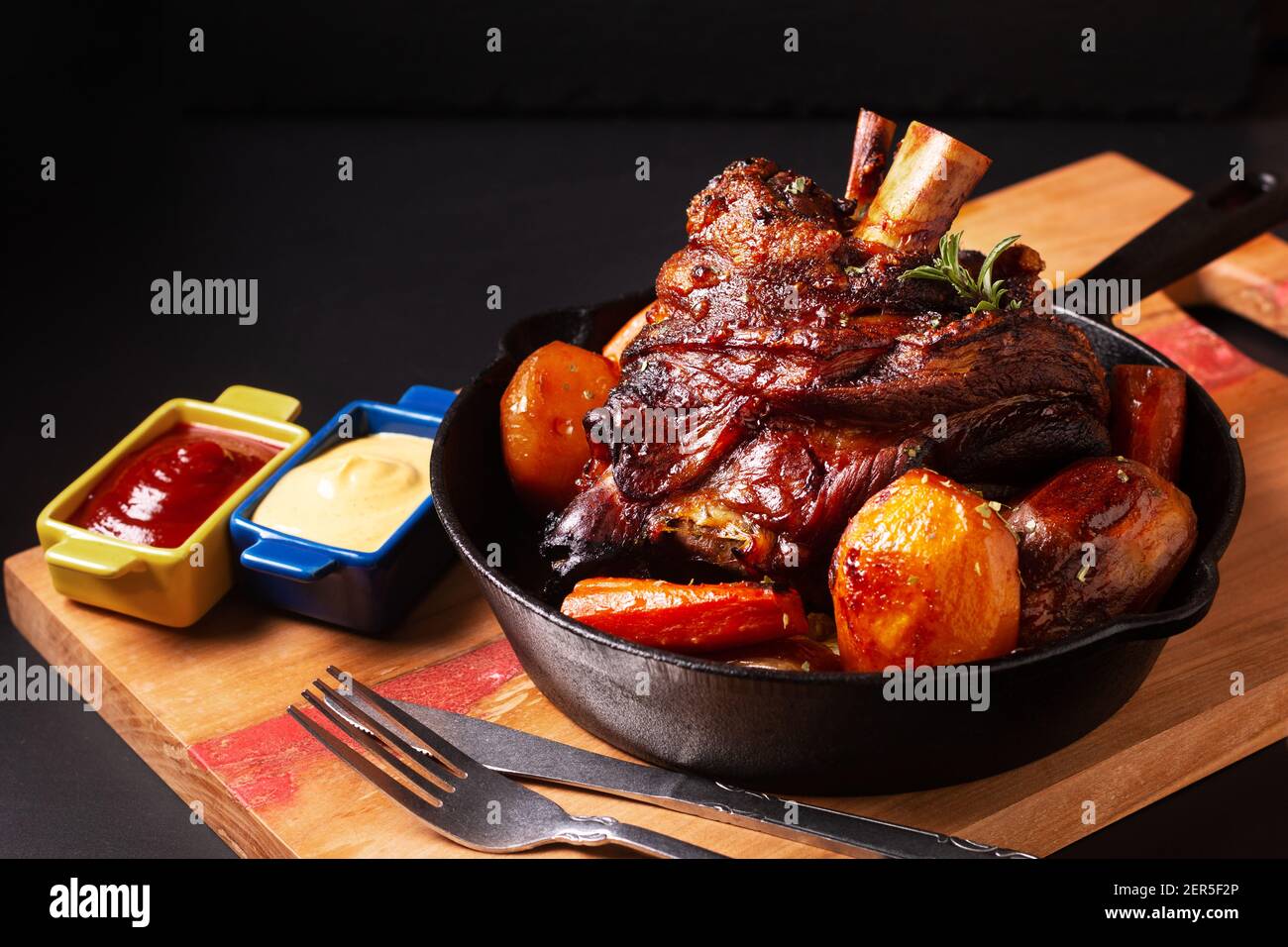 Concetto di cibo punto focale fatto in casa birra rustica arrosto di maiale croccante Articolazione arrostita in padella di ferro con spazio per la copia Foto Stock