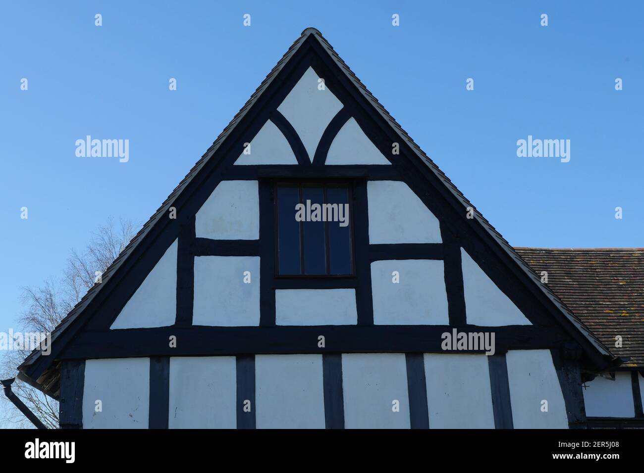 Legno bianco e nero incorniciato periodo medievale Casa, tetto Gable con finestra, antico inglese tradizionale edificio dal Medioevo Foto Stock