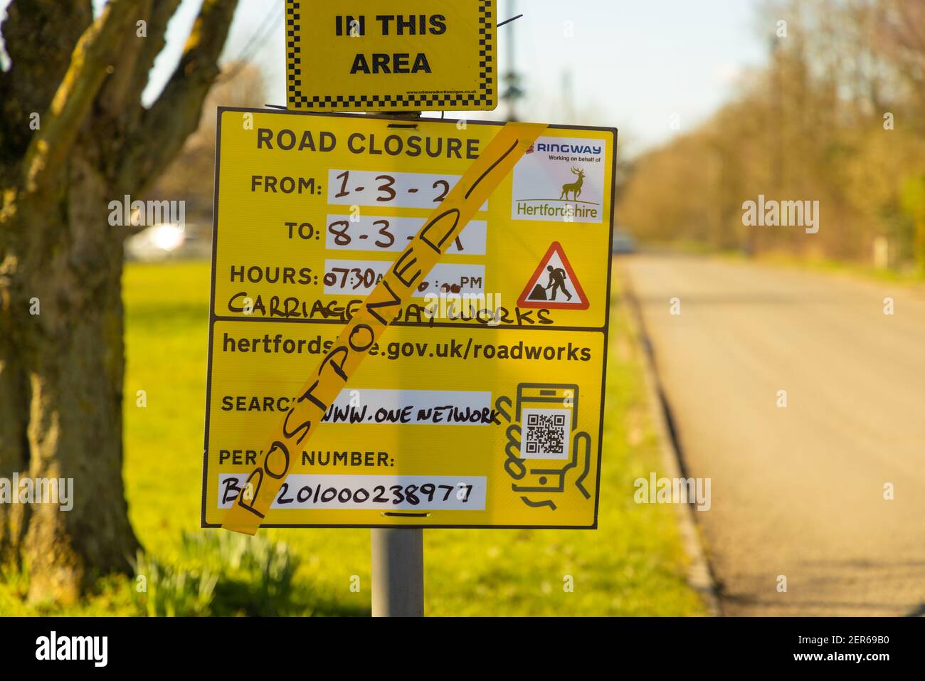 Cartello di avviso di chiusura della strada in una strada di campagna, con la parola "rimandato" sopra la parte anteriore. Febbraio 2021, Hertfordshire. REGNO UNITO. Foto Stock
