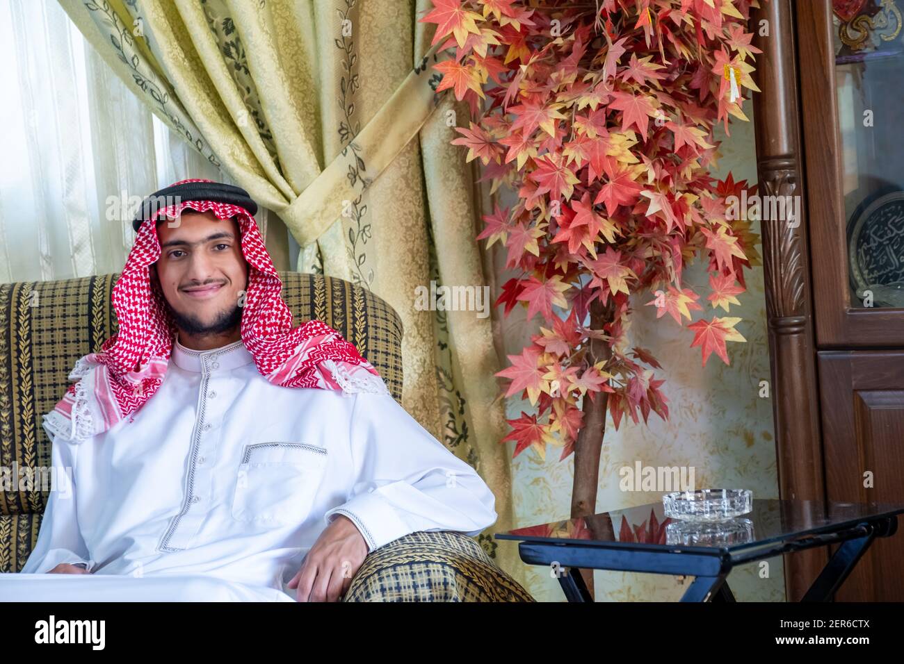 L'uomo musulmano seduto sul divano si sente felice Foto Stock