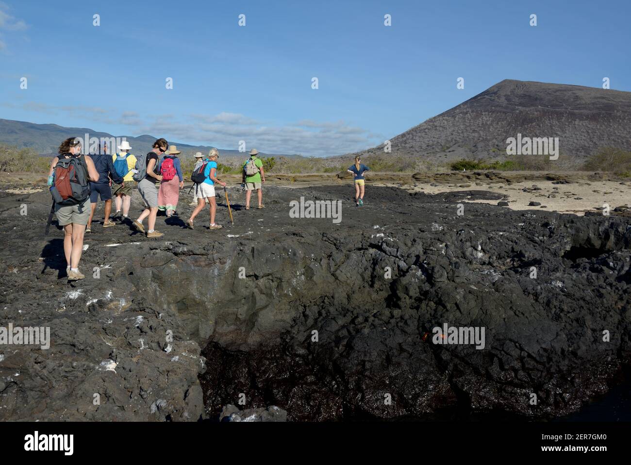 Turisti che camminano sulla lava a Puerto Egas, Isola di Santiago, Isole Galapagos, Ecuador Foto Stock