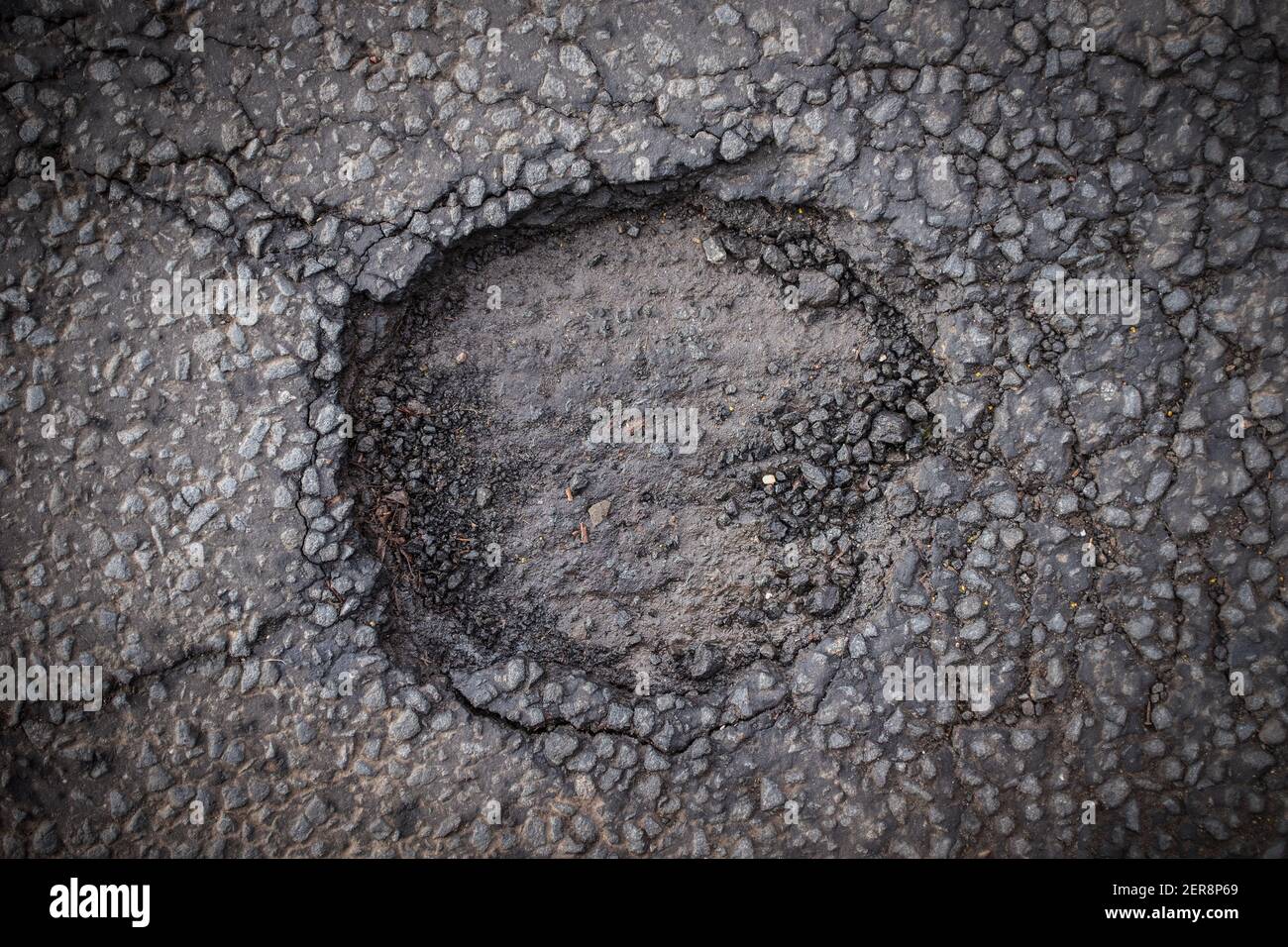 Un pericoloso Pothole in una strada cittadina, dall'alto Foto Stock