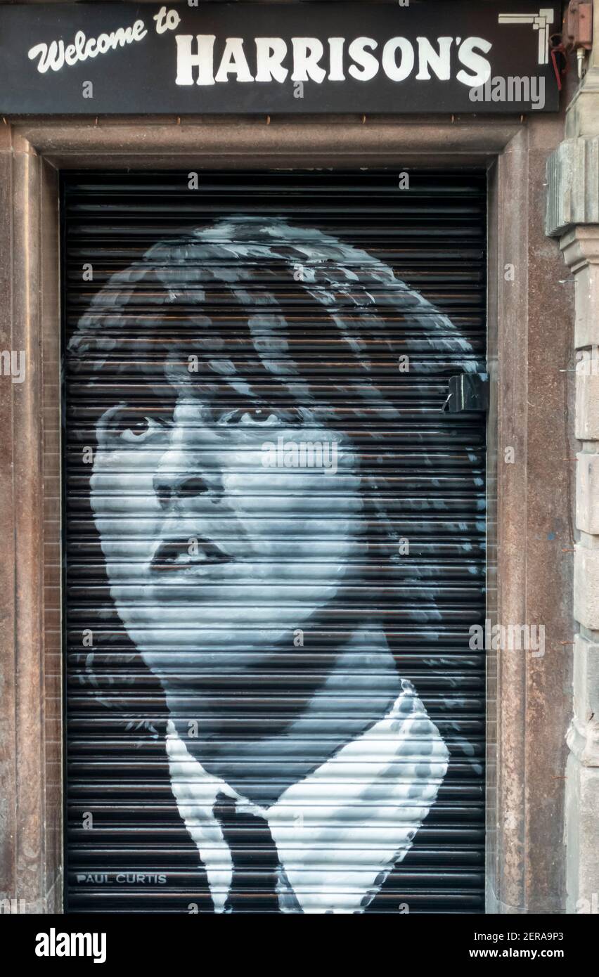 L'immagine del chitarrista dei Beatles George Harrison sull'otturatore chiuso di Harrison's Bar & Kitchen nel centro di Liverpool Foto Stock
