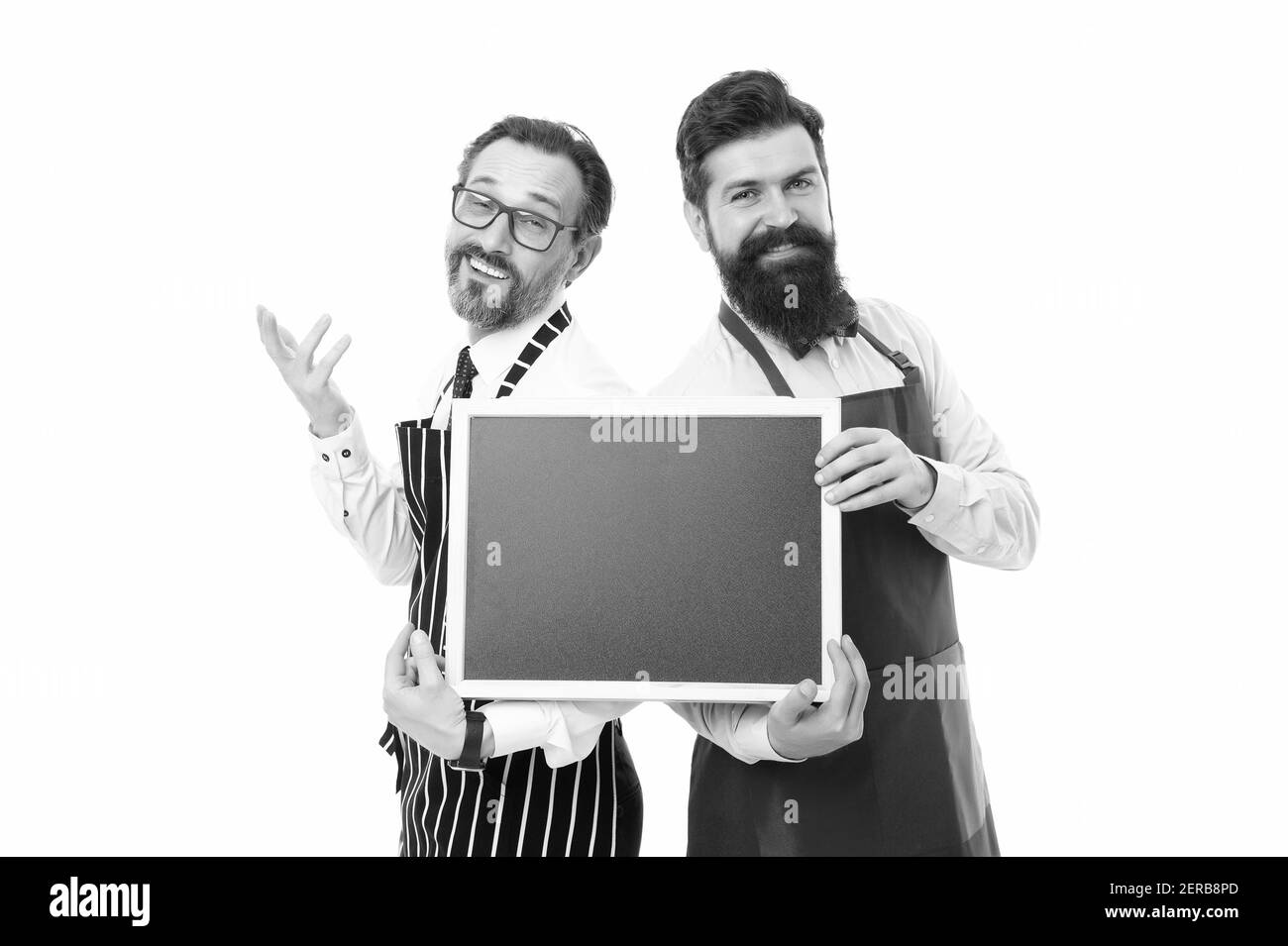 Spazio di copia per la lavagna con spettacolo di barman Hipster. Assunzione di personale del ristorante. Gli uomini sopportavano informando le ore felici. Gli uomini barman sopportato in grembiule tengono la lavagna vuota. Barista con pubblicità blackboard. Foto Stock