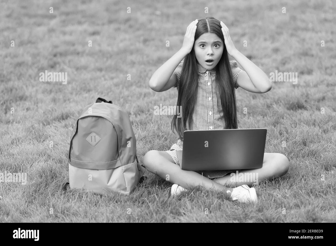 hanno alcuni problemi. formazione online. ritorno a scuola. teen girl usare il computer su erba verde. bambino con zaino e notebook. nuova tecnologia nella vita moderna. studio. scioccato bambino che lavora su laptop. Foto Stock