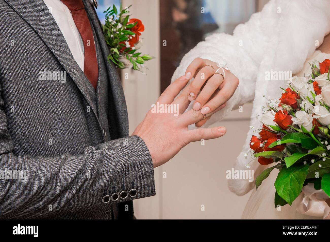 La mano dello sposo mette l'anello di nozze sui pollici dello sposo in su. Foto Stock
