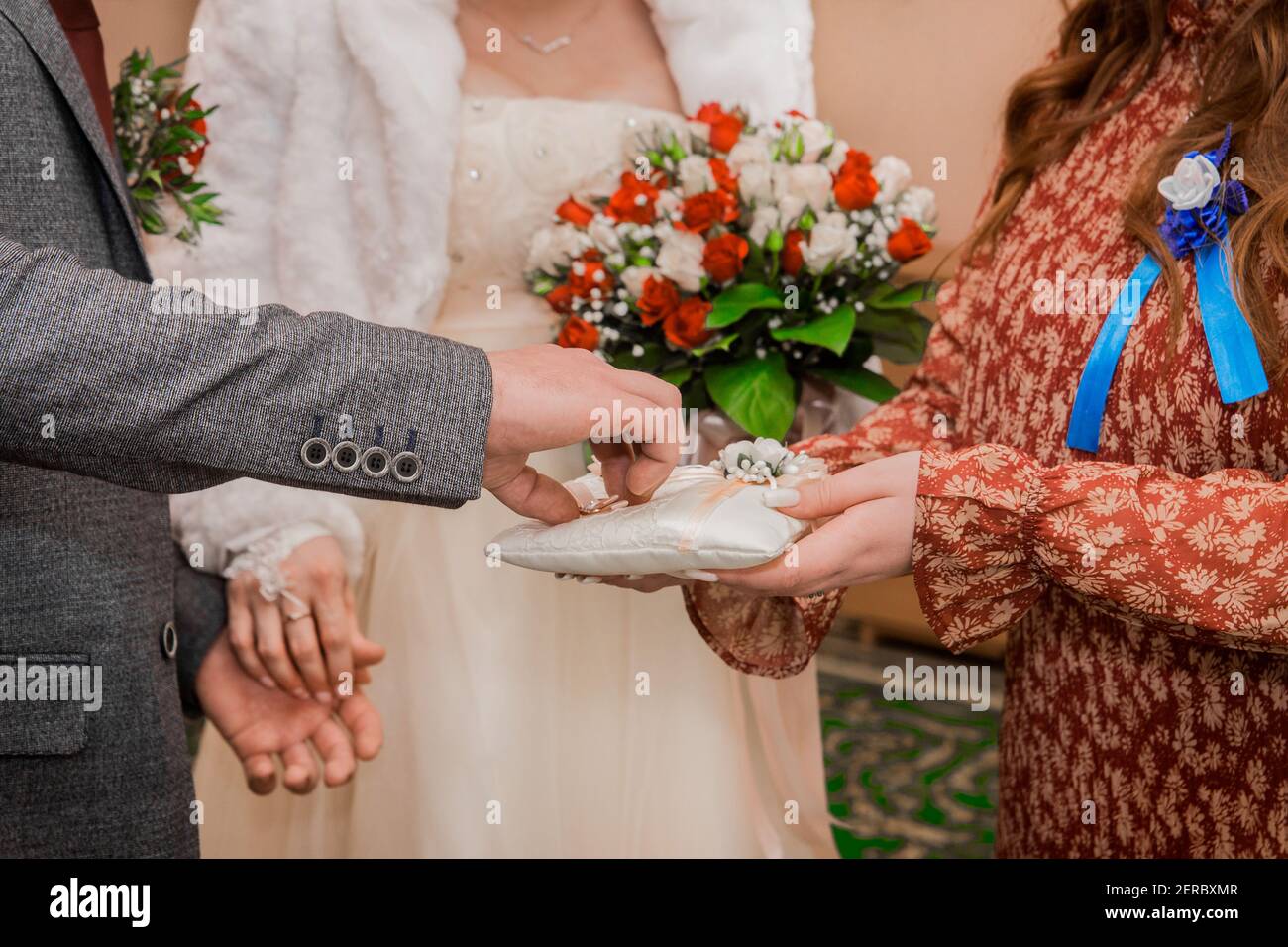 Le mani del testimone al matrimonio danno gli anelli di matrimonio dello sposo. Scambio di anelli di nozze. Foto Stock