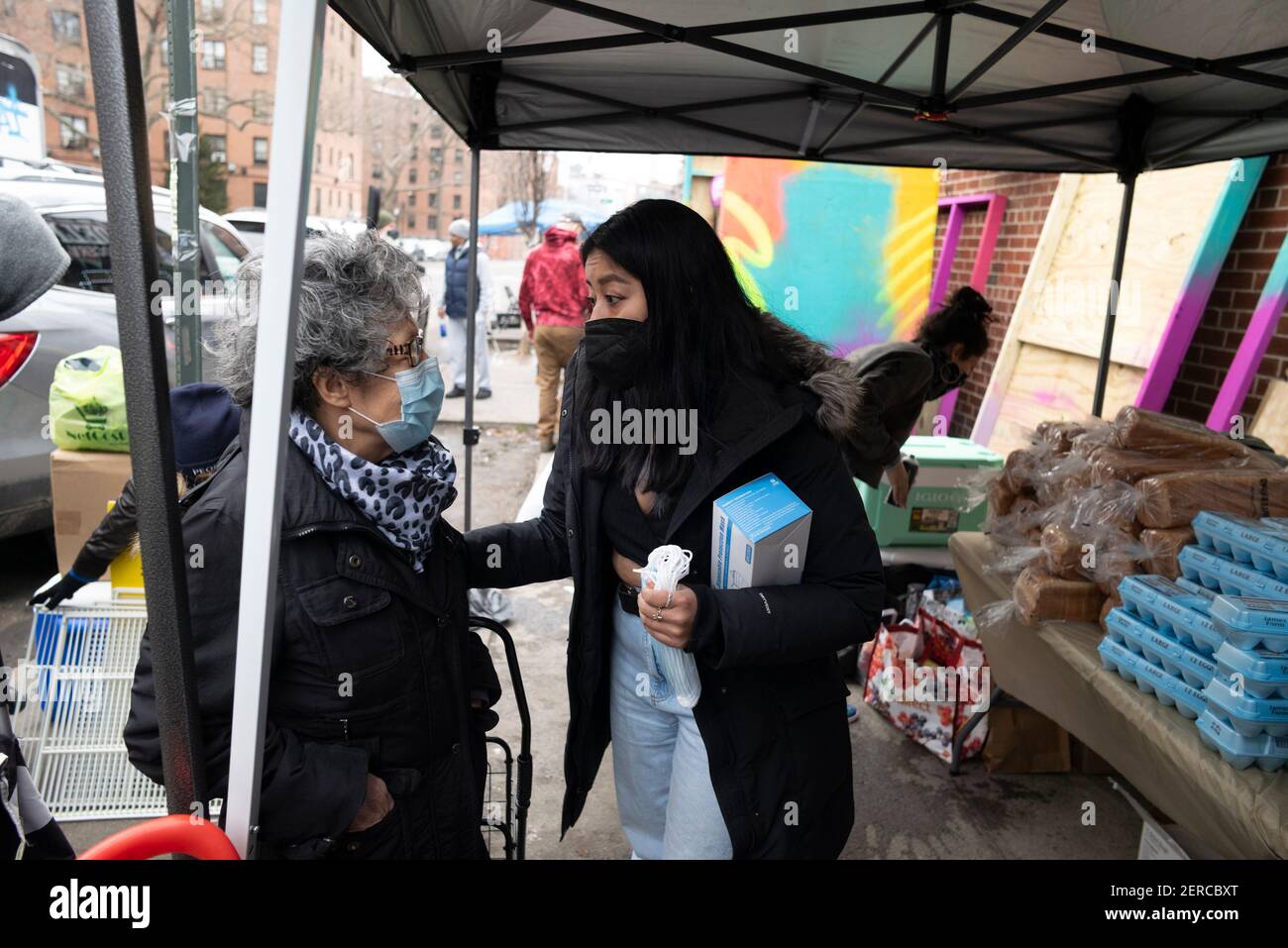 New York, New York, Stati Uniti. 28 Feb 2021. SANDRA PEREZ, a sinistra della comunità di Quuensbridge, parla con L'organizzatore della comunità GRACE FRUTOS durante la riapertura del Queensbridge Community Frigo sulla 40th Avenue a New York. Oltre 500 libbre di cibo, vestiti e deperibili sono stati donati. Frutos ha detto "questo nuovo frigorifero è vegetariano, caricato con frutta e verdura e stiamo saltando che promuoverà uno stile di vita più sano e cibo più sano per la comunità. "Una volta che questo frigorifero è appropriato per la comunità, speriamo di costruire un secondo frigorifero. (Credit Image: © Brian Branch Price/ZUMA W Foto Stock