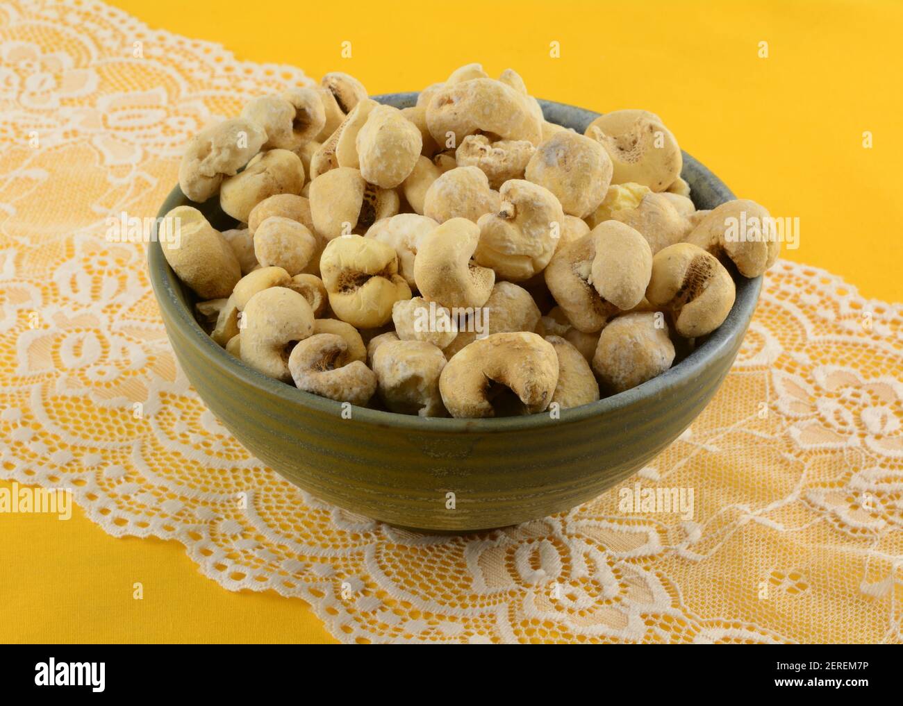 Pannocchie brasiliane di mais dolce bollitore in ceramica snack ciotola on corridore tavolo in pizzo bianco su tovaglia gialla Foto Stock