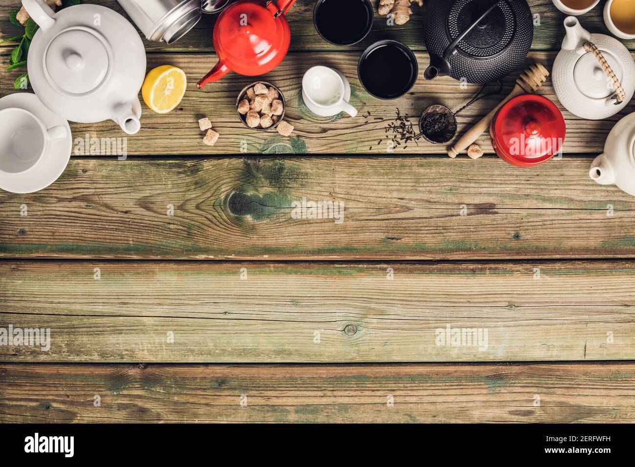 Vari tè e teiera composizione, erbe essiccate, tè verde, nero e tè matcha su sfondo tavola di legno, piatto posa, spazio copia Foto Stock