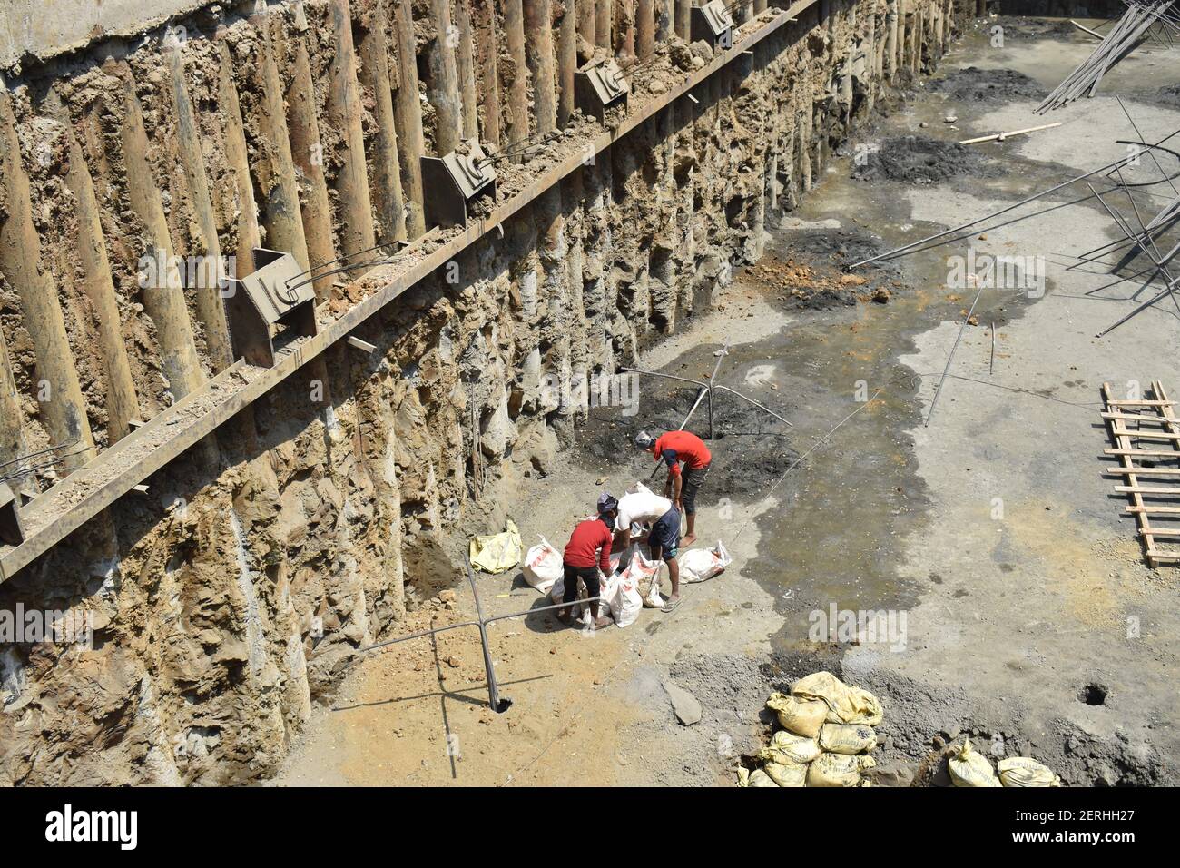 ancoraggio di roccia a cantiere. lavoratori che fabbricano cemento e calcestruzzo manualmente con le mani Foto Stock